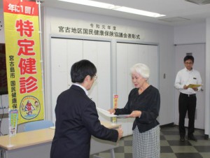 濱川会長（左）が健康保持に努めた市民を表彰した＝19日、市役所平良庁舎