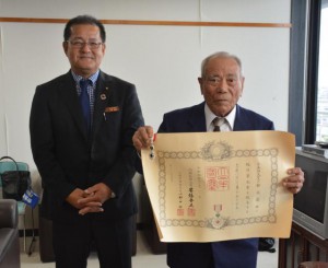 高齢者叙勲を受章した狩俣さん（右）と山里議長＝３日、市役所平良庁舎