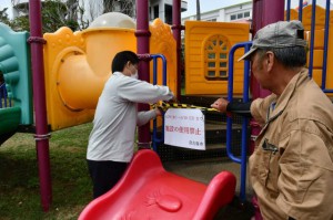 市関係者らが利用禁止の告知文を遊具に設置した＝28日、盛加越公園