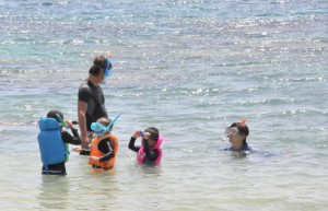 海水浴を楽しむ親子。国内移動の自粛要請全面解除で観光客の増加が見込まれる＝20日、下地島の中の島海岸