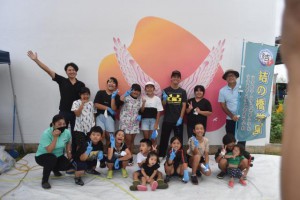 参加者らは「さしばの翼」壁画の完成を祝って記念撮影した＝28日、みやこ下地島空港ターミナル