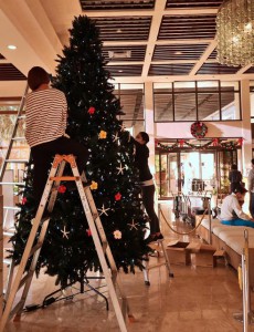 12月を前にホテルのスタッフらがクリスマスツリーの設置作業を行っていた＝30日、市内のホテル