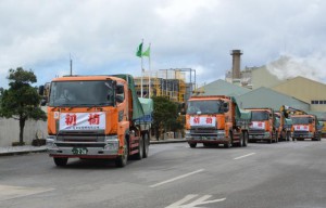 初荷の粗糖を積んだトラックが平良港へ向けて出発した＝８日、宮古製糖城辺工場