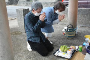 旧十六日祭では先祖に手を合わせ供養が行われた＝２月27日、久貝墓地団地