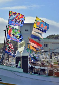 コロナ禍の静かな旧正月となったが大漁旗は、風を受けて力強くはためいた＝12日、佐良浜漁港