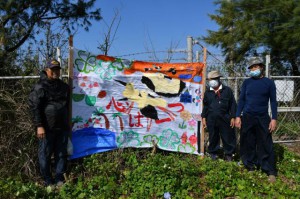 東河小の児童から届いた応援旗が「清流」の姿が確認される農業用貯水池に設置された＝10日、伊良部佐和田