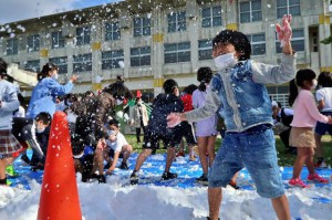 届けられた雪に大はしゃぎの子どもたち＝18日、砂川小学校