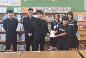 砂川晃慶さん（前列左）から砂川昌璃君（同右）へ寄付金が贈られた＝23日、砂川小学校