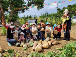 多くのカボチャを収穫し笑顔を見せる子供たちと関係者＝塩川口原の本村さんの畑