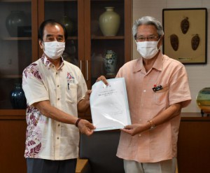 砂川会長（左）が座喜味市長に要請書を手渡した＝12日、市役所