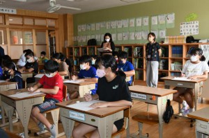 岡田さんの説明を聞きながらサシバを描く児童たち＝４日、伊良部島小・中学校